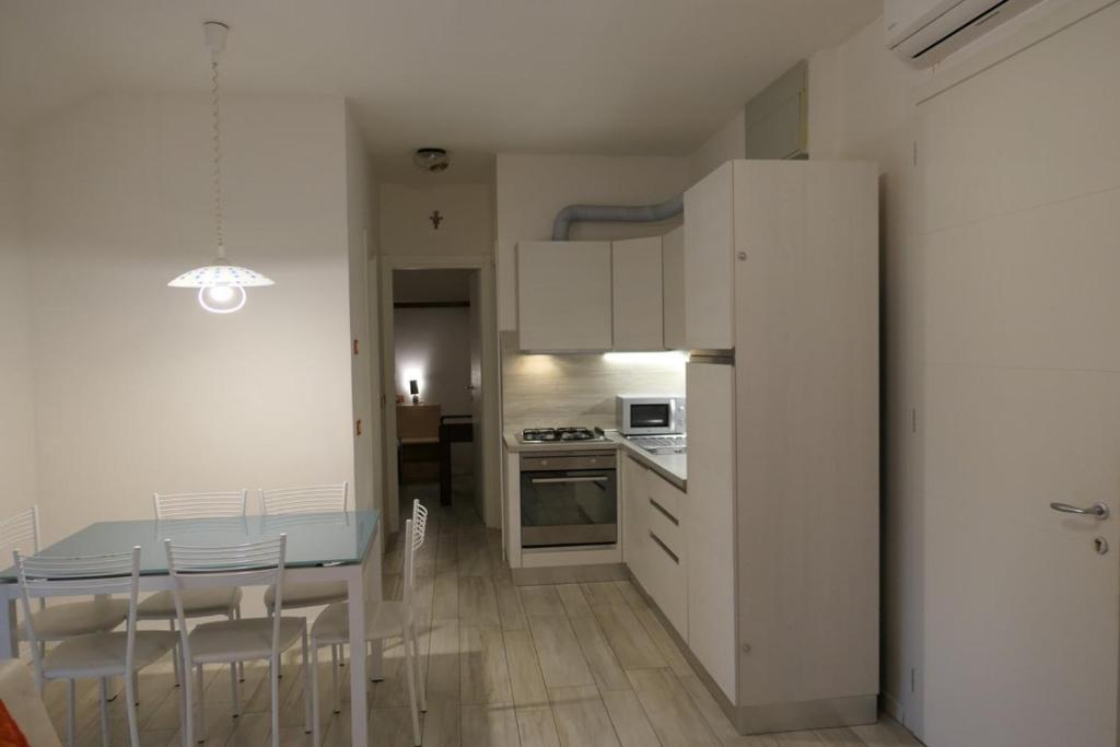 a kitchen and dining room with a table and chairs at Quadrifoglio 43 in Bibione