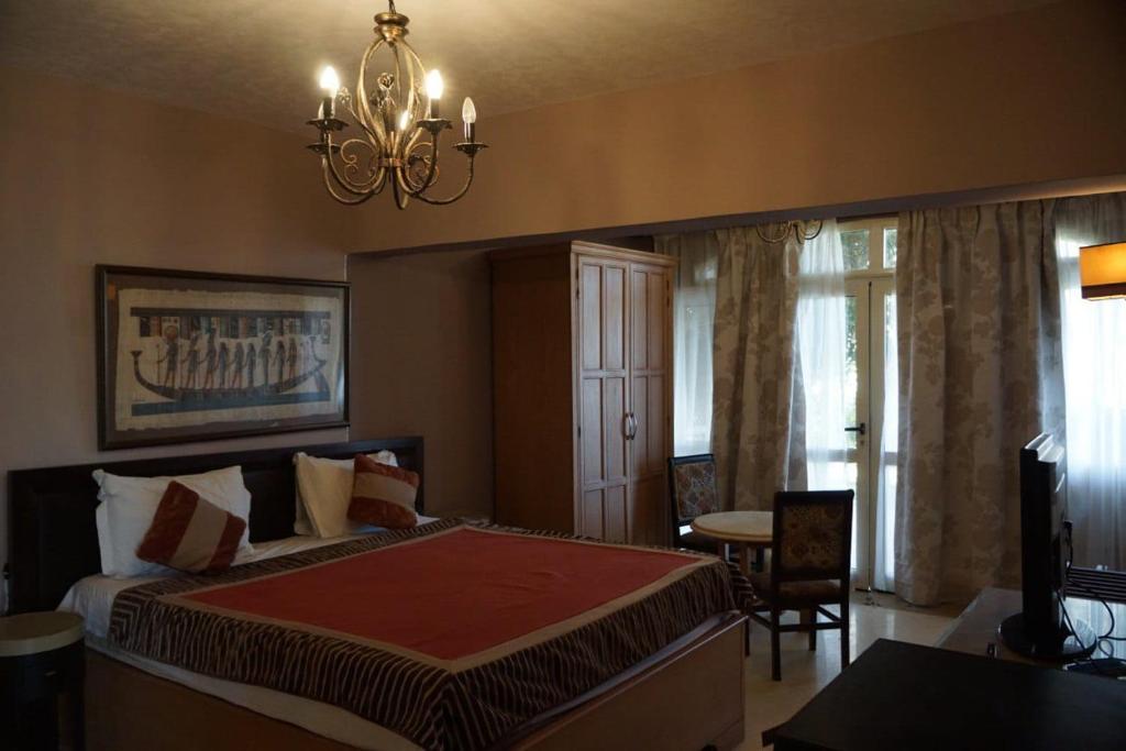 a bedroom with a large bed and a chandelier at Adel's villa in Sharm El Sheikh