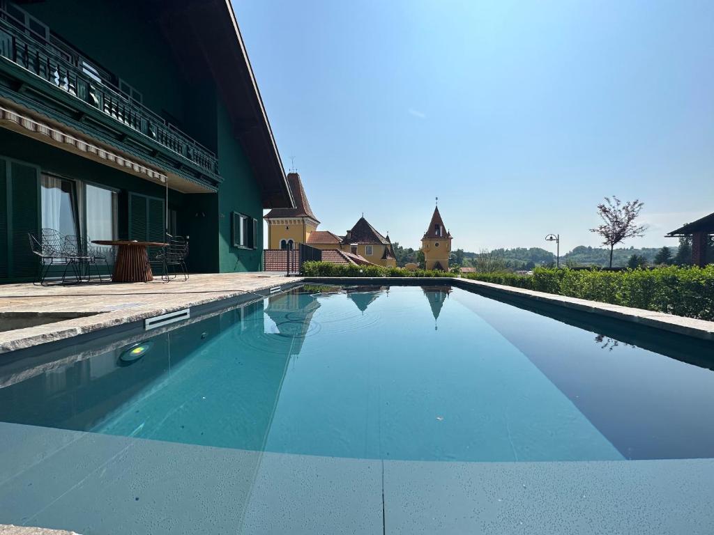 a swimming pool in front of a building at Chalet beim Georgi Schloss in Ehrenhausen