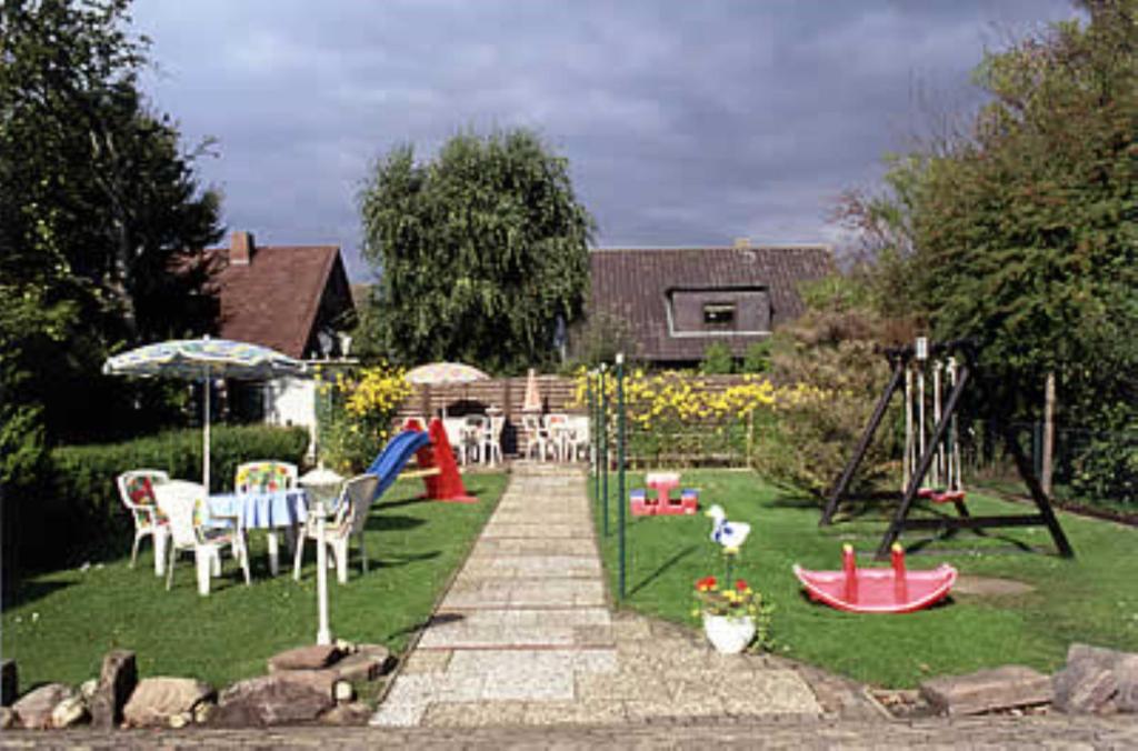 a backyard with a playground with a swing set at Haus Nordseegruß 2 in Cuxhaven