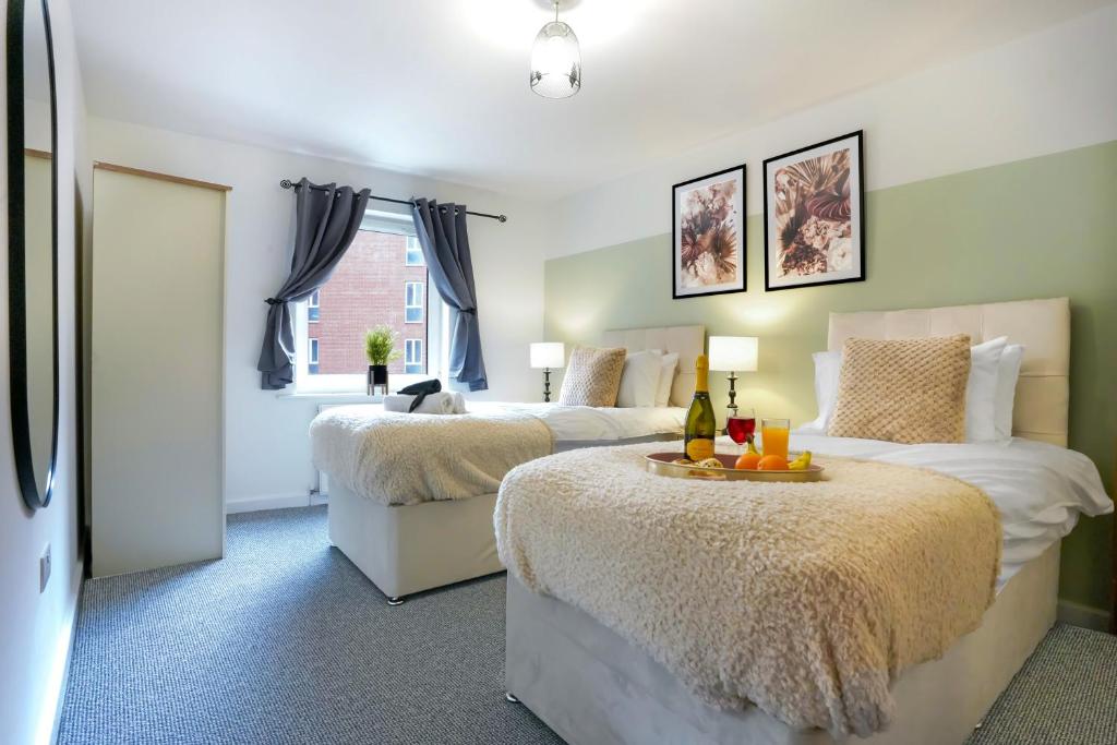a bedroom with two beds and a window at City Centre Apartment with Free Parking, Balcony, Super-Fast Wifi and Smart TV with Netflix by Yoko Property in Northampton