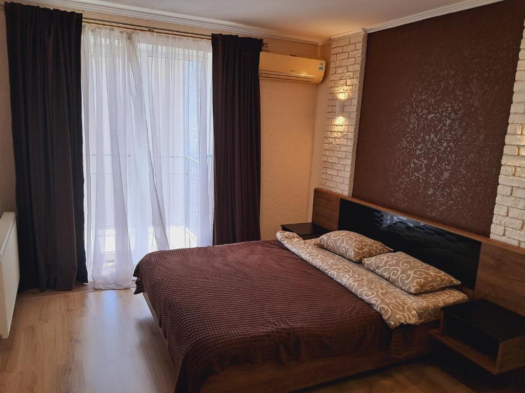 a bedroom with a bed and a large window at New modern apartments in the center in Ivano-Frankivsk