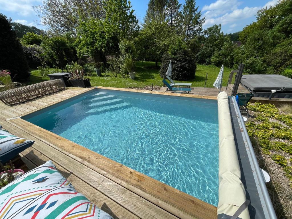 a swimming pool with a wooden deck and a swimming poolvisor at Le Clos Dessyag in Montcavrel