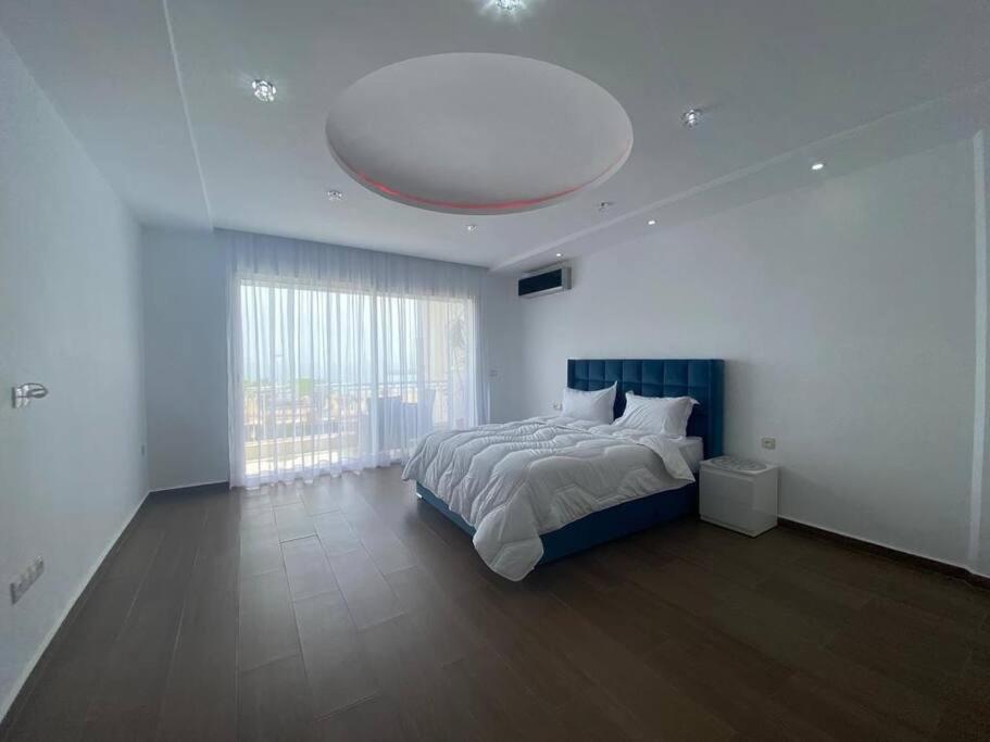 een slaapkamer met een groot bed en een groot raam bij Lovely Seaview beachfront Apartment in Agadir