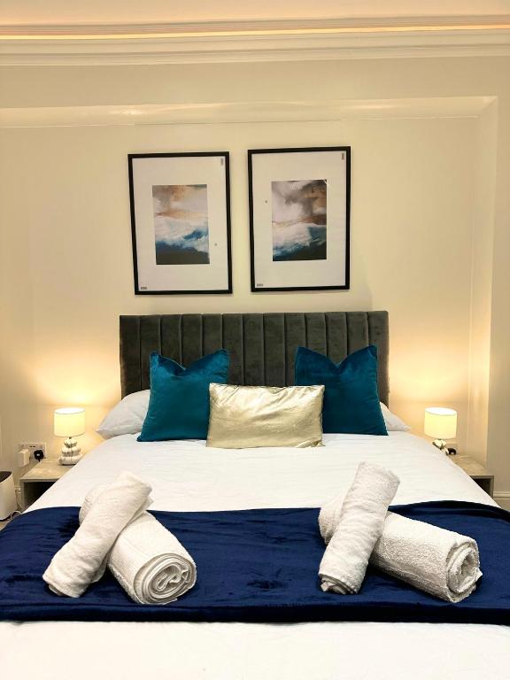 una camera da letto con un grande letto con cuscini blu di London Charm - Stylish Studio in Kensington a Londra
