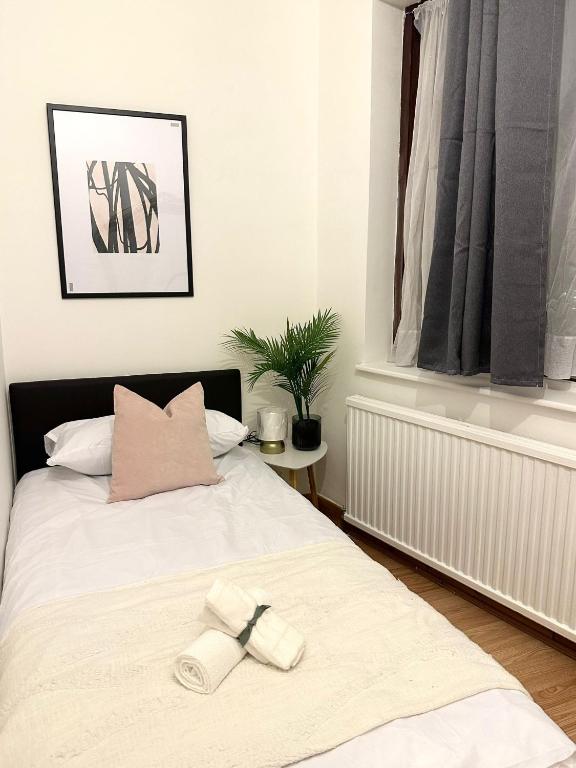 London Charm - Comfortable Room in Spacious House tesisinde bir odada yatak veya yataklar