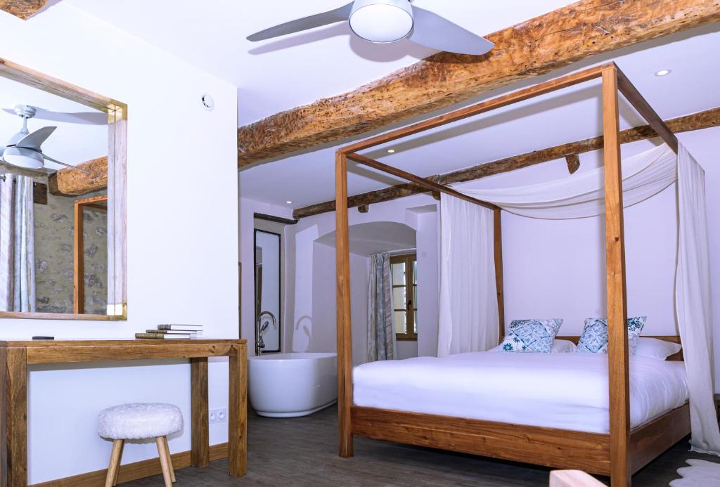 Schlafzimmer mit Himmelbett und Spiegel in der Unterkunft Cottage - La Maison du Château - By DOMAINE RIBERACH in Bélesta