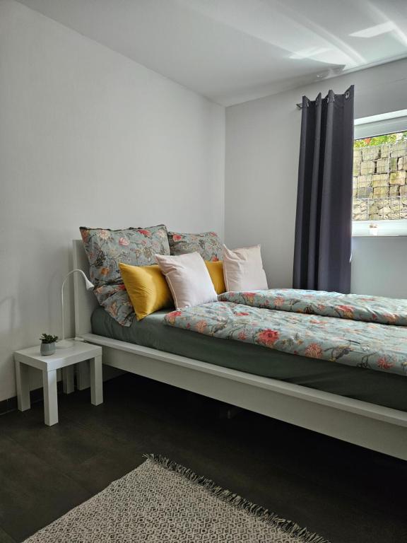 ein Schlafzimmer mit einem Bett mit Kissen und einem Fenster in der Unterkunft Gemütliche Wohnung in ruhigem Wohngebiet in Aschaffenburg