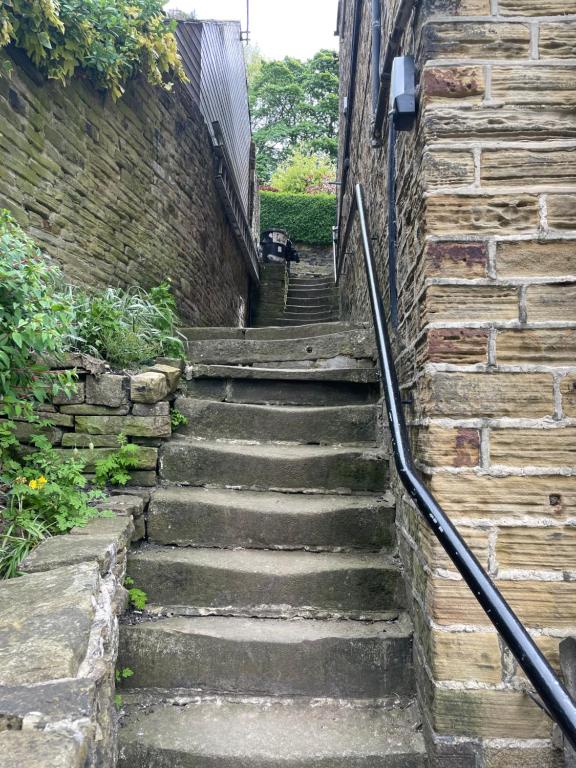 a set of stone stairs next to a brick wall at Brook Cottage in Holmfirth