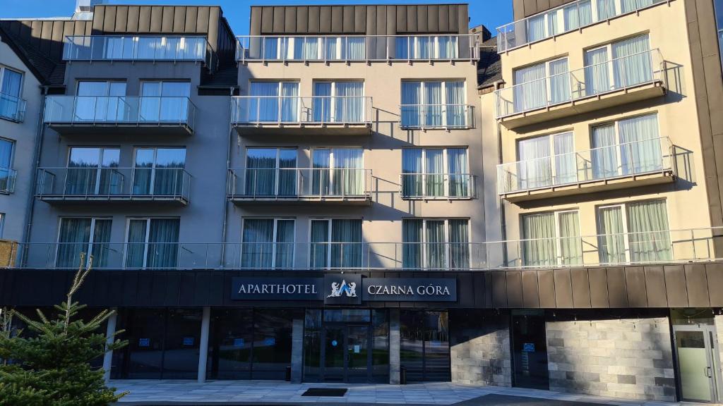 an apartment building with a sign in front of it at Aparthotel Apartamenty Czarna Góra 331 in Sienna