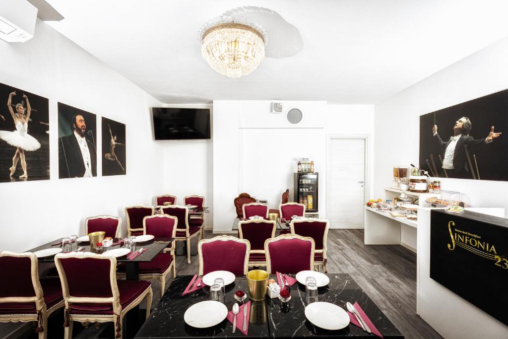 un restaurante con mesas y sillas de color púrpura y una lámpara de araña en Sinfonia 23 en Rávena