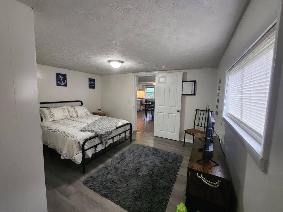 een slaapkamer met een bed, een televisie en een raam bij Couples lake house retreat. in Dayton