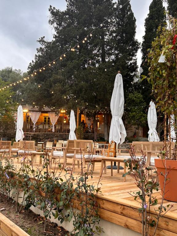 un patio con mesas, sombrillas blancas y luces en CAMPING GALLINA VARJA en Sotta