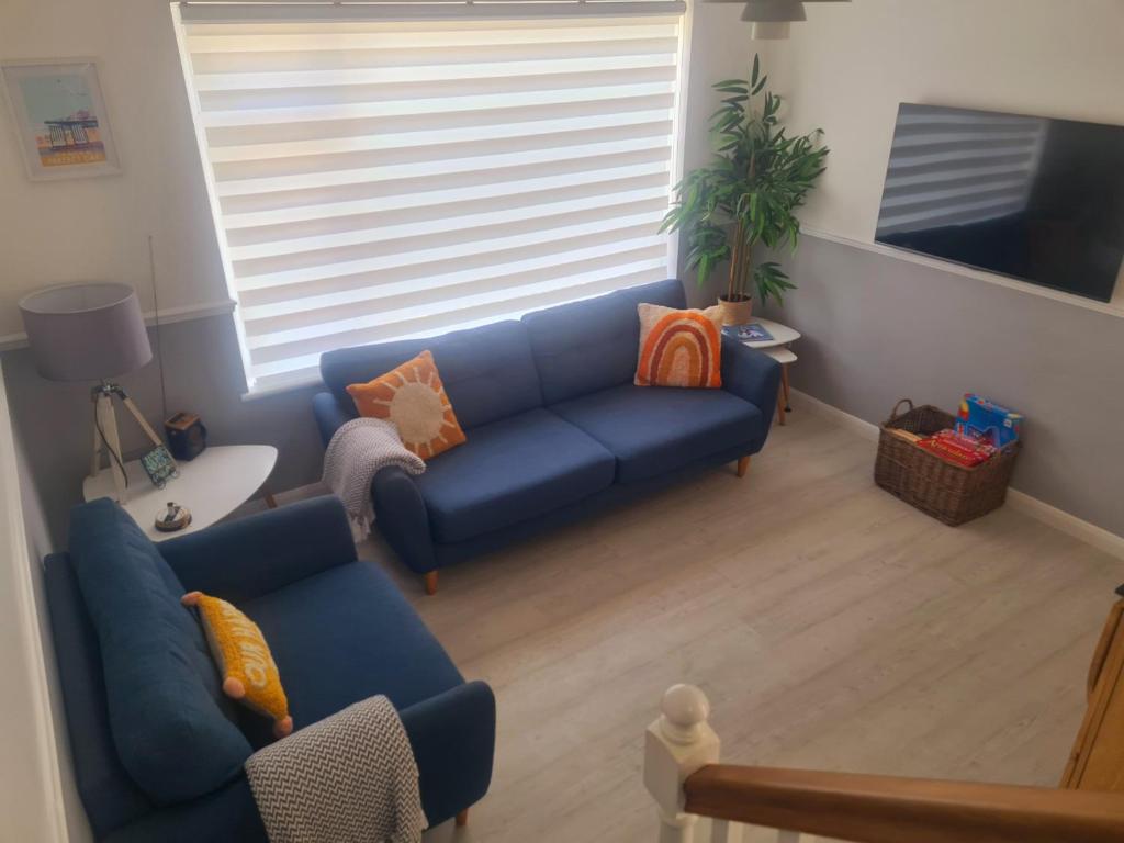 uma sala de estar com um sofá azul e uma janela em Private 2 bedroom house close to the beach em Paignton