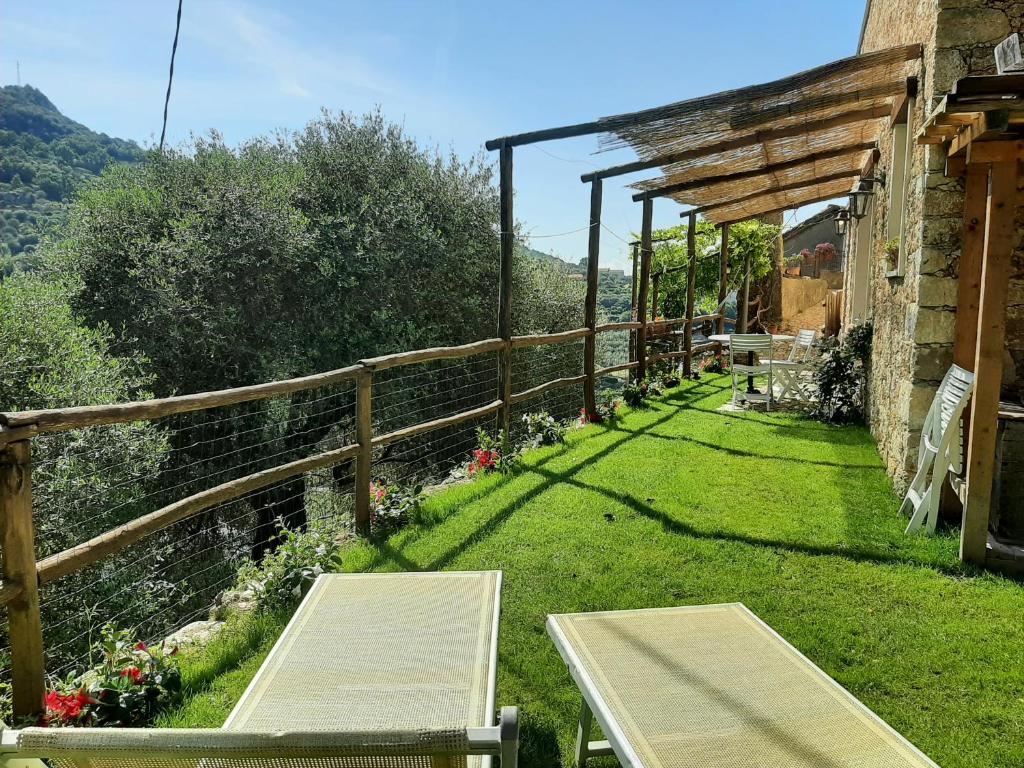 een tuin met een tafel en banken in het gras bij Contrada Bolla 2 in Finale Ligure