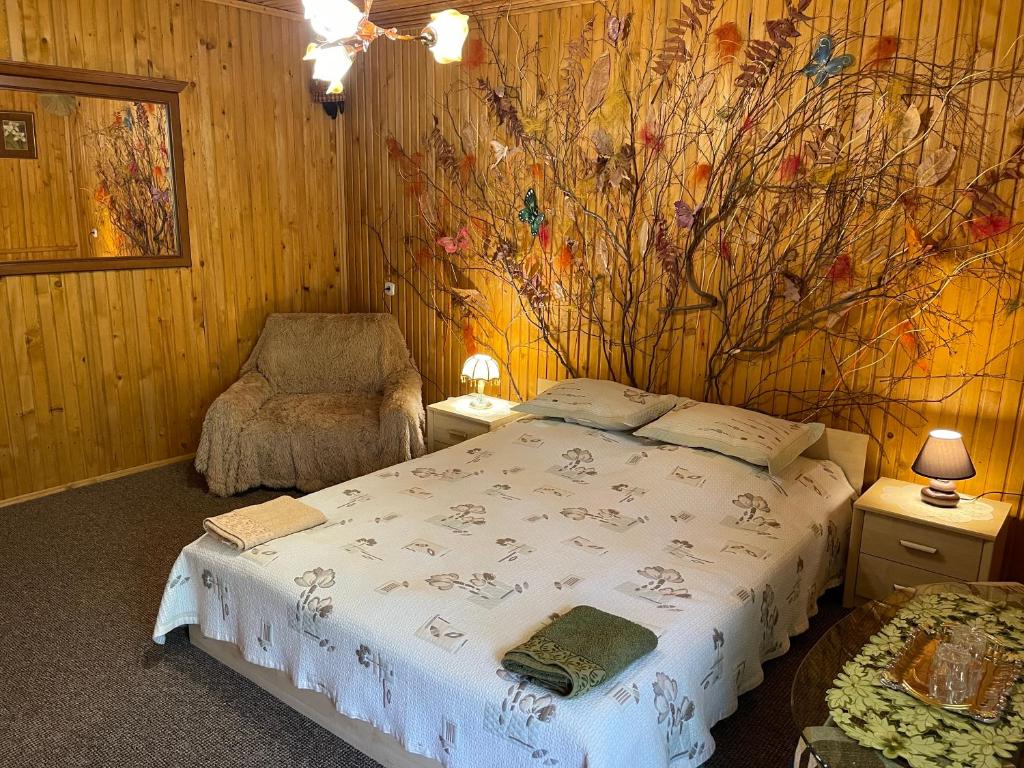 a bedroom with a bed and a flower mural on the wall at Grunok (Adults only) in Pilipets