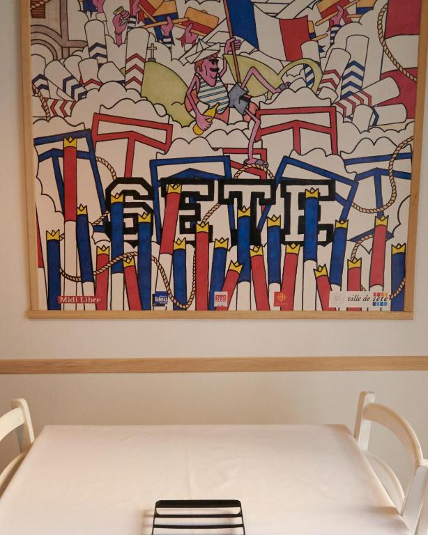 une table devant une peinture murale dans l'établissement Bel appartement centre ville Sète, à Sète