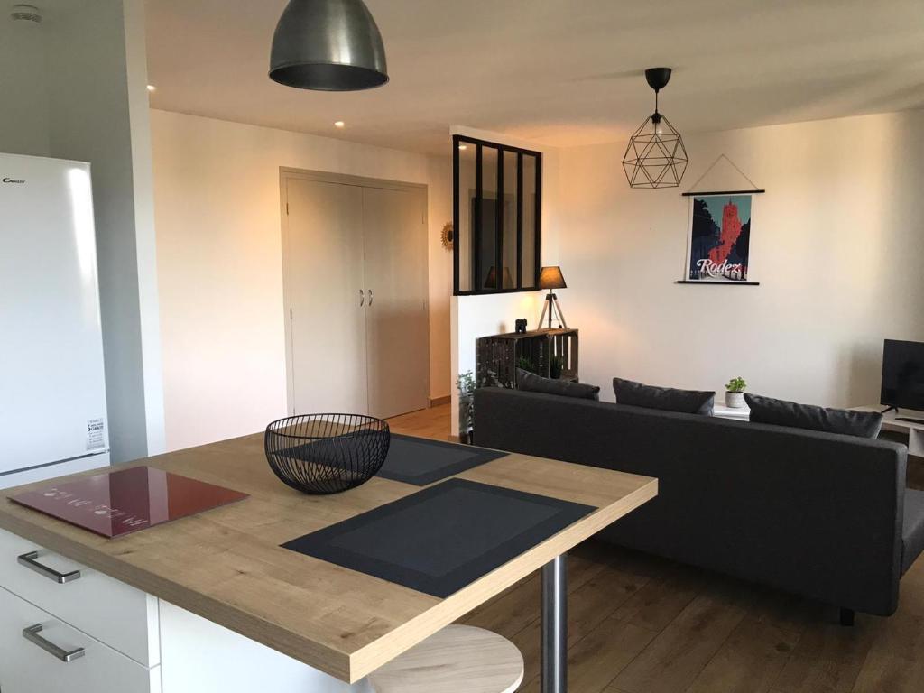 een woonkamer met een tafel en een bank bij T2 50m2 3*,centre ville,calme,lumineux charme in Rodez