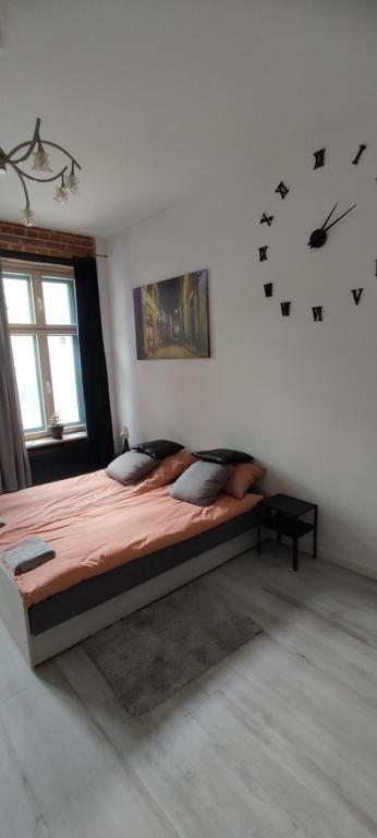 a bedroom with a large bed and a clock on the wall at LIBERation! in Olsztyn