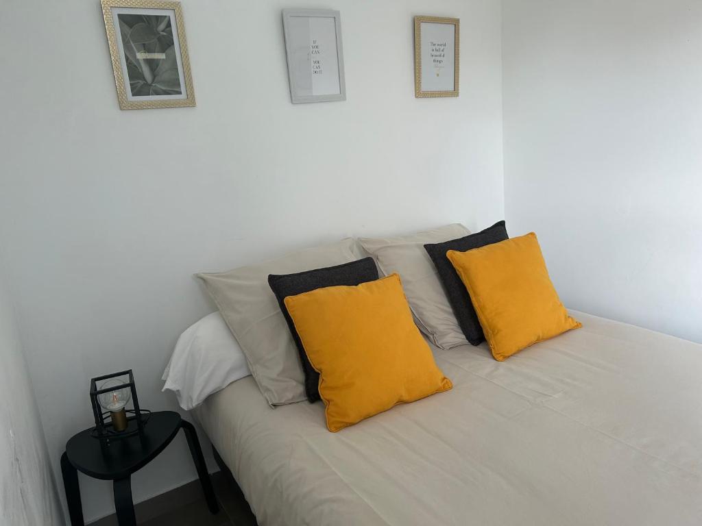 eine weiße Couch mit zwei gelben Kissen drauf in der Unterkunft La belle étoile in Roye