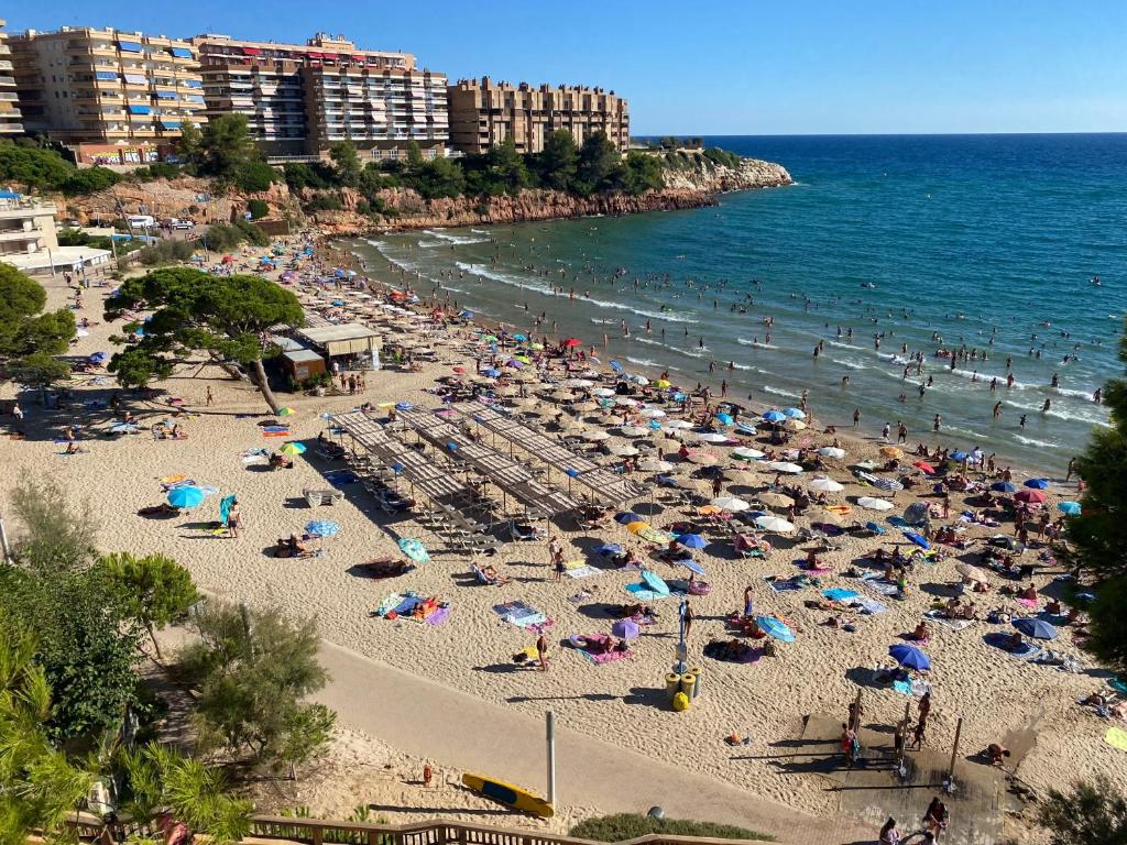 a beach filled with lots of people and the ocean at Beautiful apartment in Salou with pool access in Salou