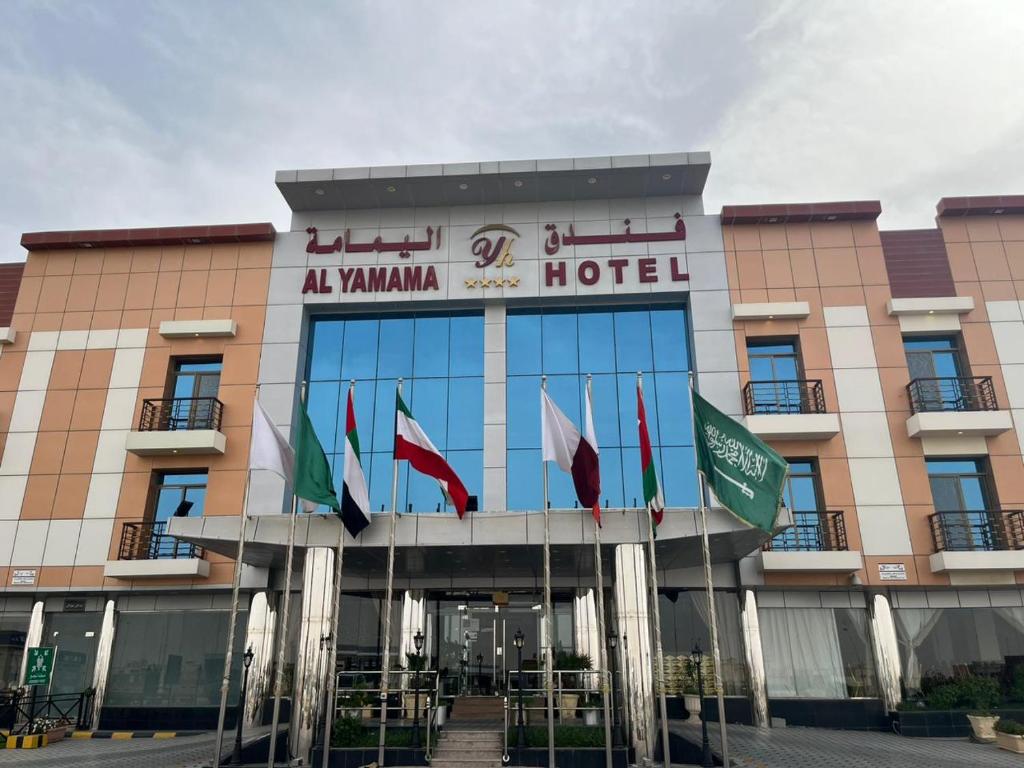 a hotel with international flags in front of it at فندق اليمامه الفندقية in Al Nairyah