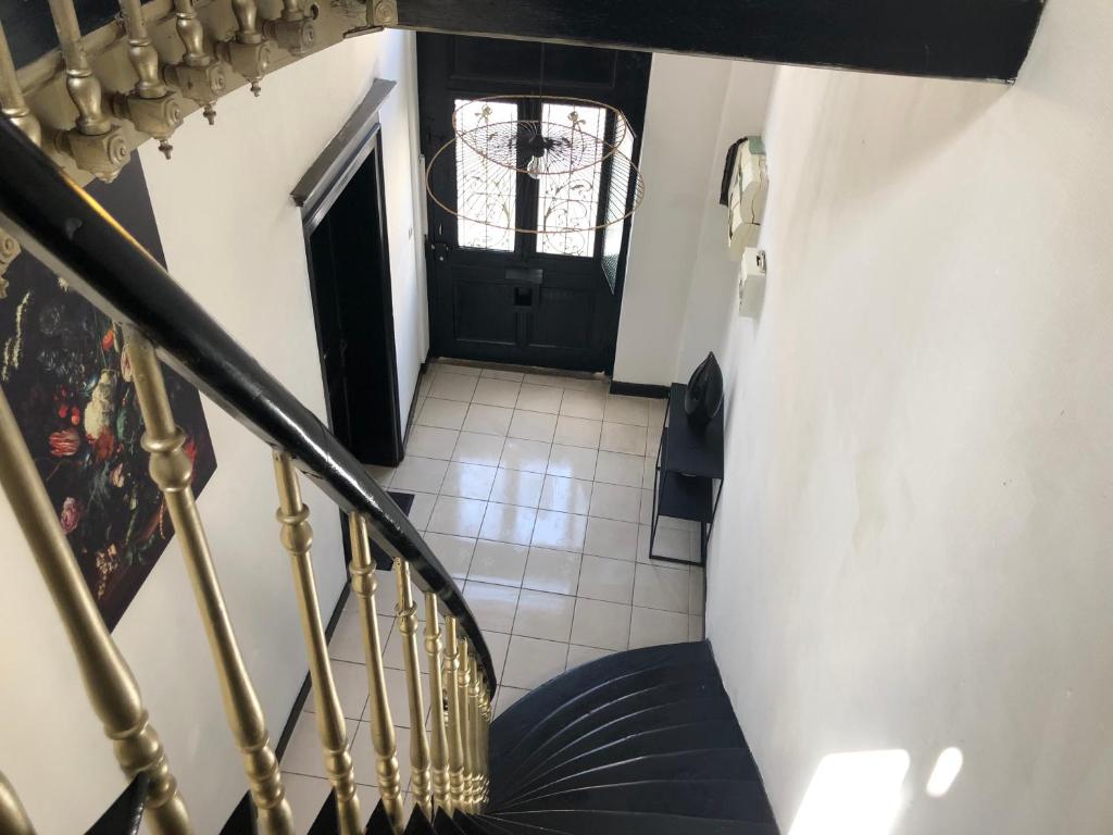 a staircase with a black door and a tile floor at La clef Sithieu in Saint-Omer