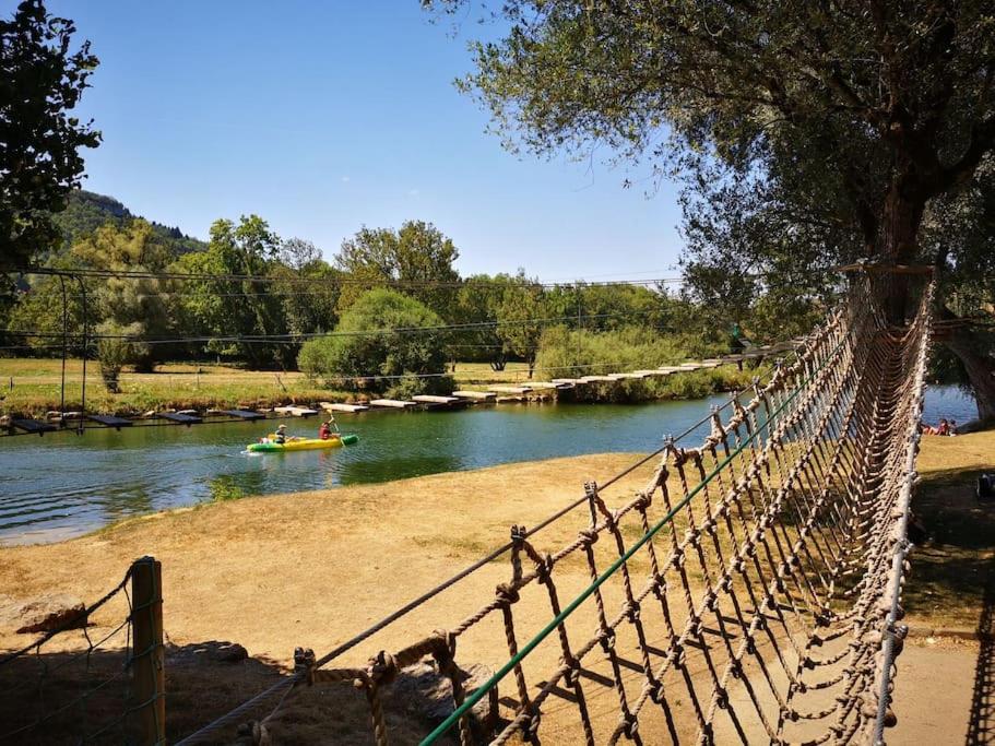 a suspension bridge over a river with people in a boat at chez Gaby 