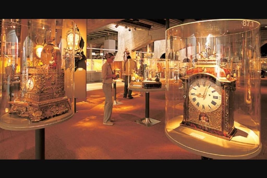 a man standing in front of a display of clocks at chez Gaby 