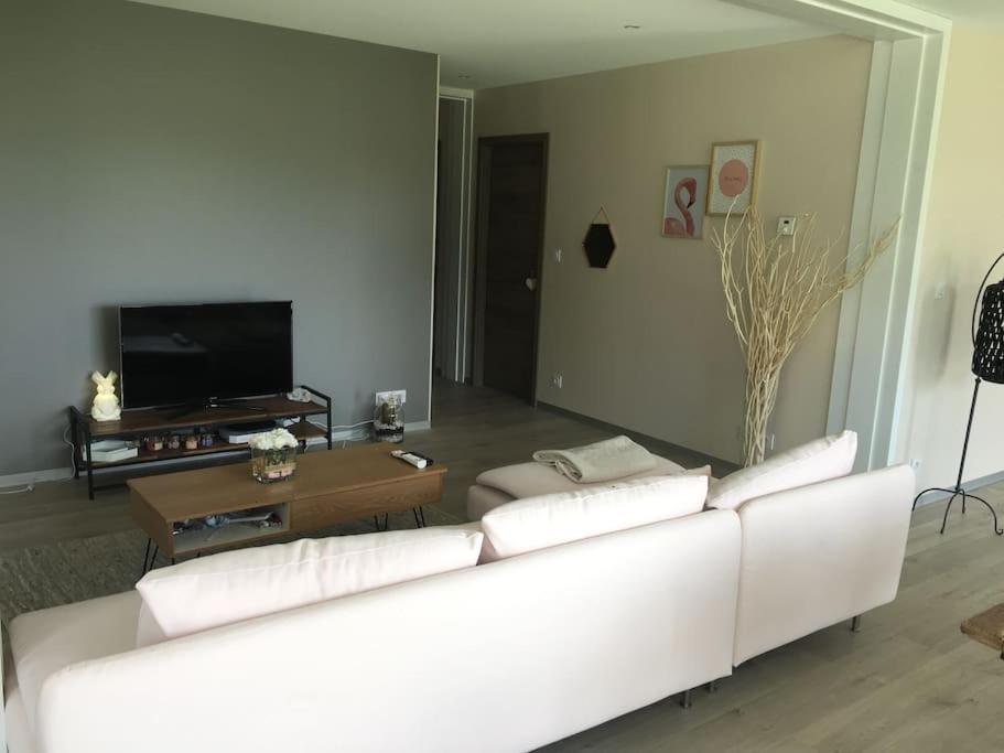 a living room with a white couch and a tv at chez Gaby 