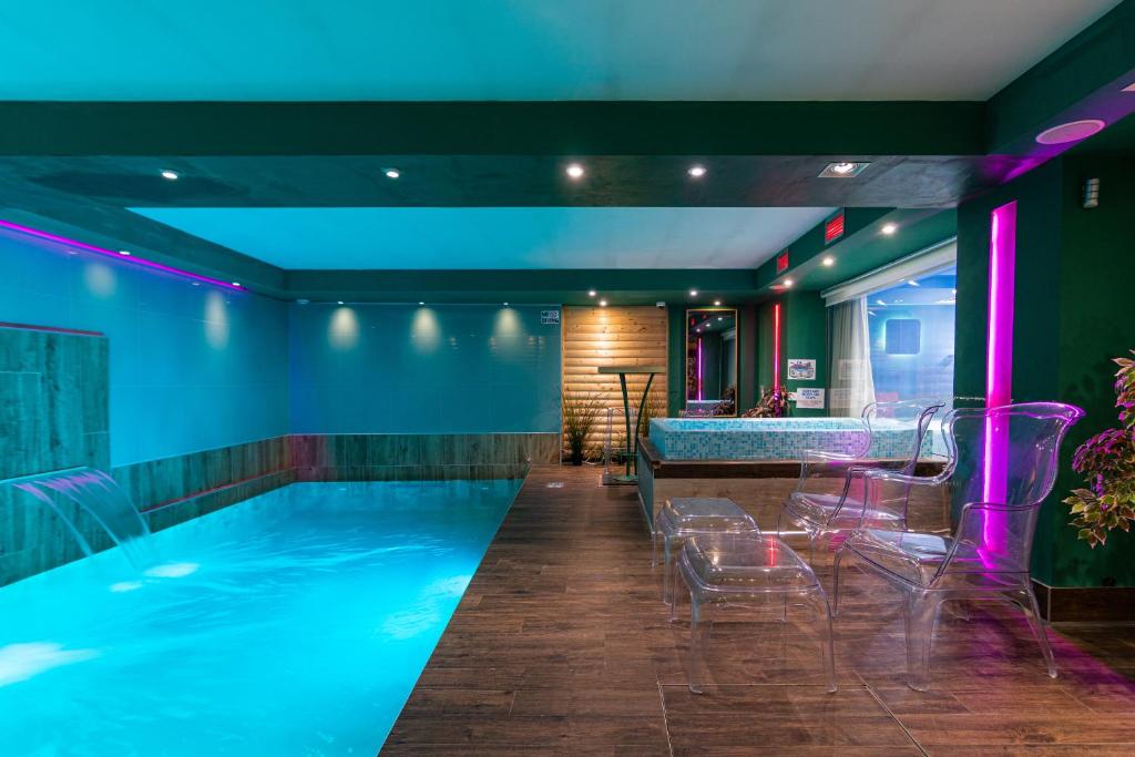 a pool in a room with a bar and chairs at Joan Apartments & Spa in Skopje