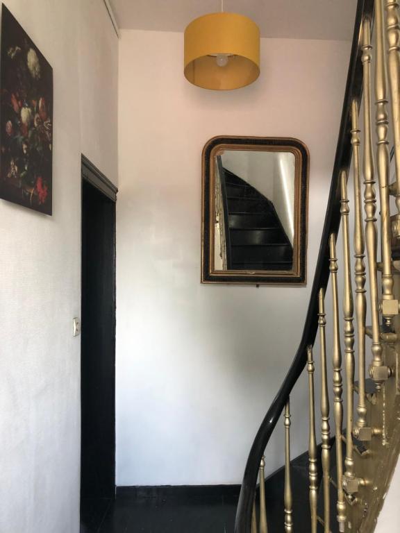 a mirror on a wall next to a stairway at La clef Sithieu in Saint-Omer