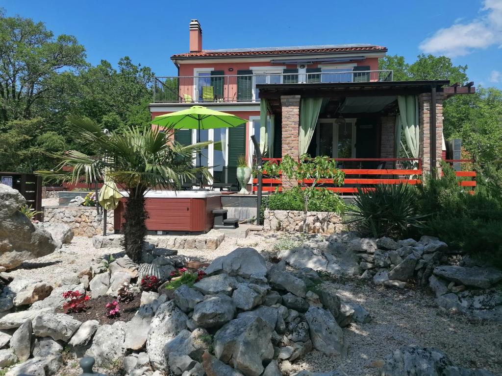 une maison avec un jardin en pierre en face dans l'établissement The Forest House Krk 1, à Kras