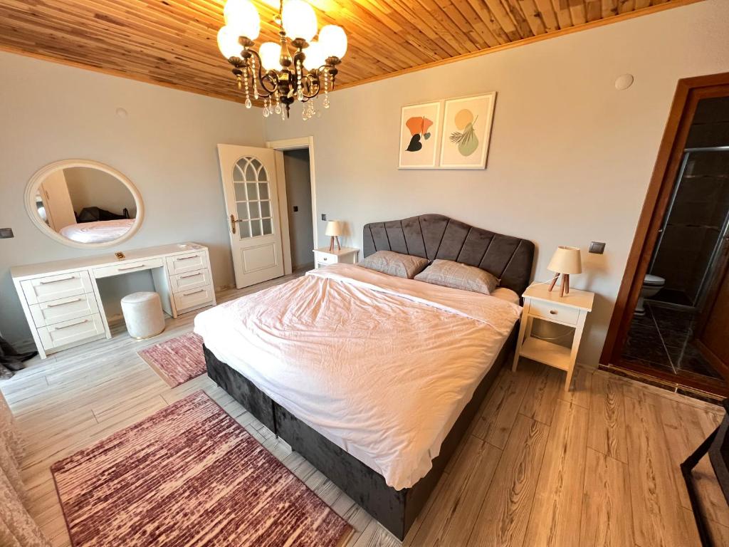 a bedroom with a large bed and a chandelier at Shen Home Life in Trabzon