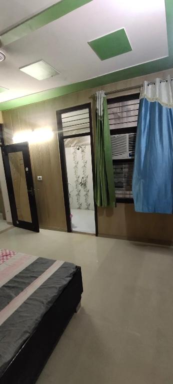 a room with a bed and a window and a door at Radha Madhav in Vrindāvan