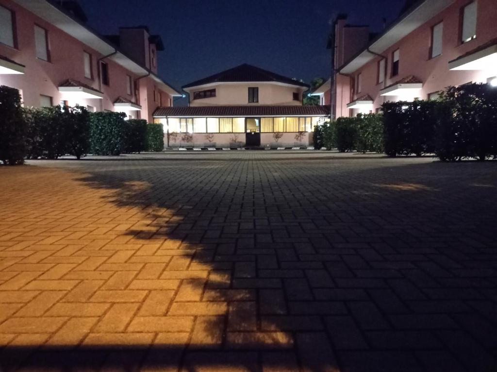 un'ombra di un albero su un cortile di mattoni di Hotel Motel Europa a Ossona