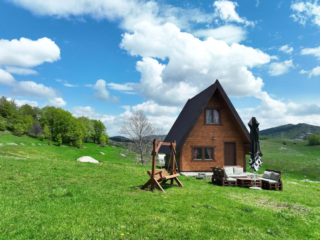 a house on a hill with a green field at Etno Idila D&D in Žabljak