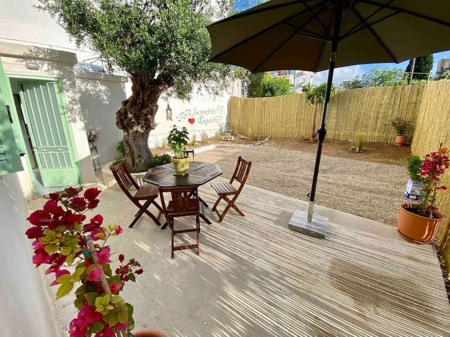 a patio with a table and chairs and an umbrella at Anastasia, downtown village house in Amalias