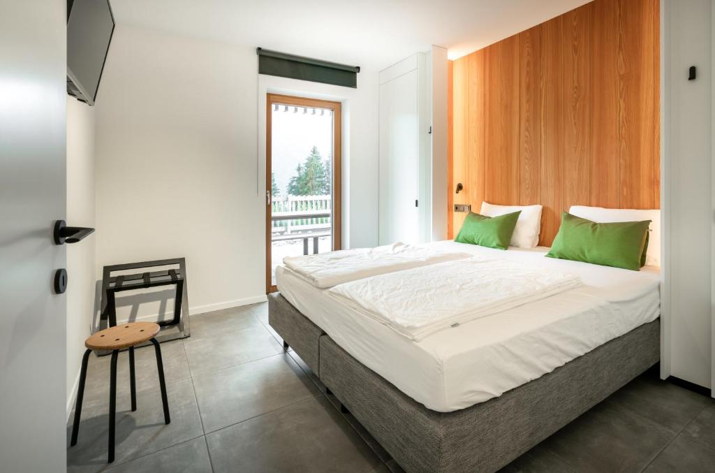 a bedroom with a large bed and a balcony at B-Lodge Kärnten in Kirchbach