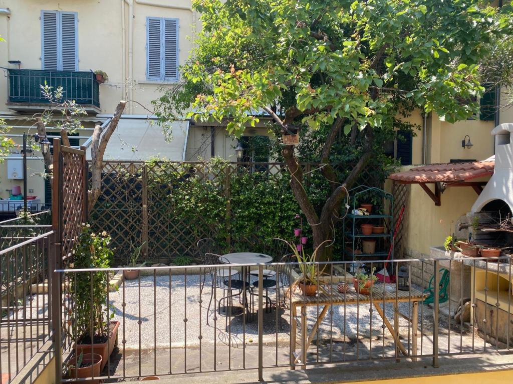 a garden with a fence and a table and a tree at Appartamento indipendente con giardino Fralù in Florence