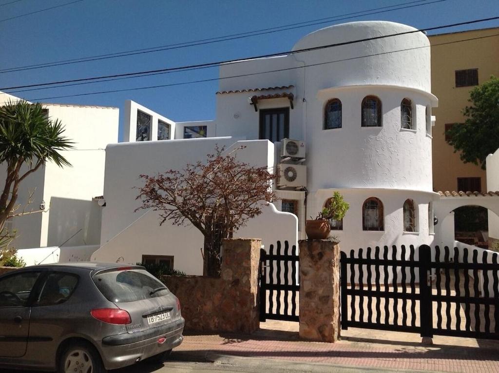 a car parked in front of a white house at Casa Joana in Cala Santanyi