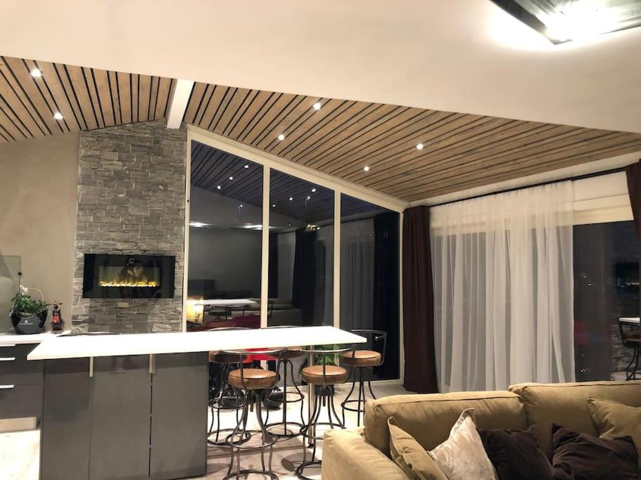 uma sala de estar com um sofá e uma cozinha com um bar em Topp moderne suite. em Larvik