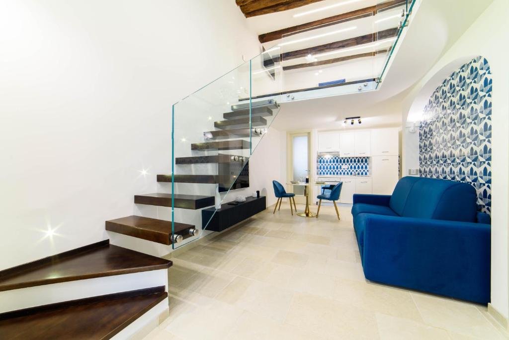 a living room with a blue couch and a staircase at Dimora Bertella boutique & SpA in Amalfi