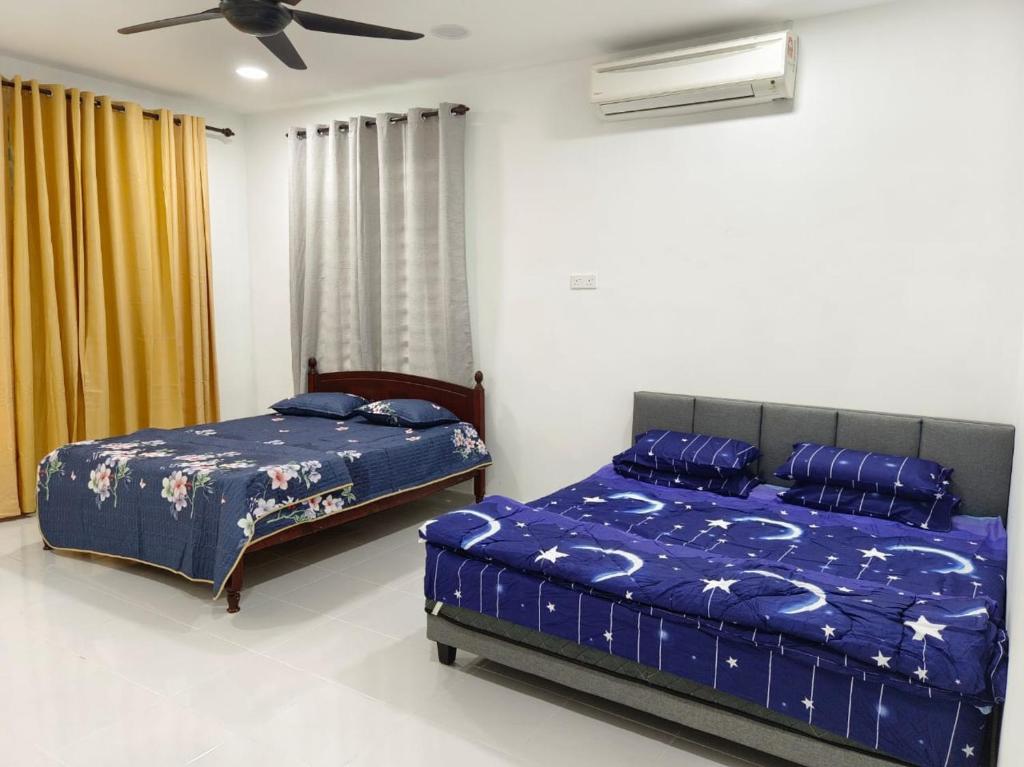 Kampong BelukarにあるHOMESTAY MYROKMAのベッドルーム1室(ベッド2台、シーリングファン付)