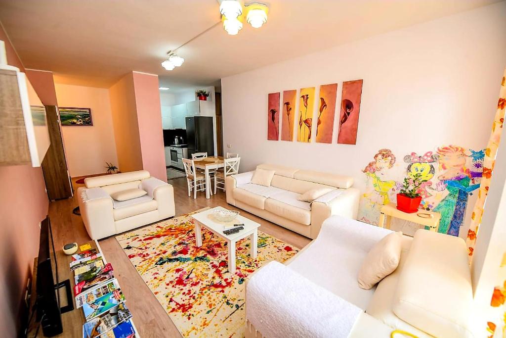 a living room with white couches and a rug at Happy stories' apartment in city centre in Shkodër