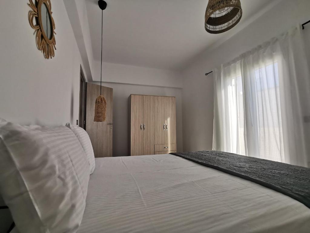 a bedroom with a white bed and a window at Mantalena's house in Antiparos