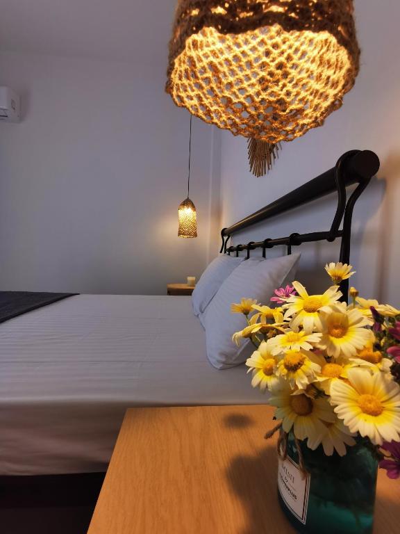 a bedroom with a bed and a table with flowers at Mantalena's house in Antiparos