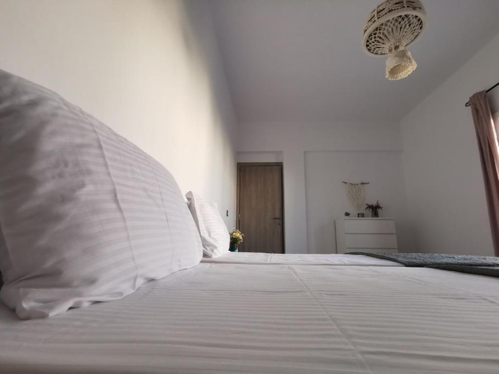 a white bed with white sheets and pillows on it at Mantalena's house in Antiparos
