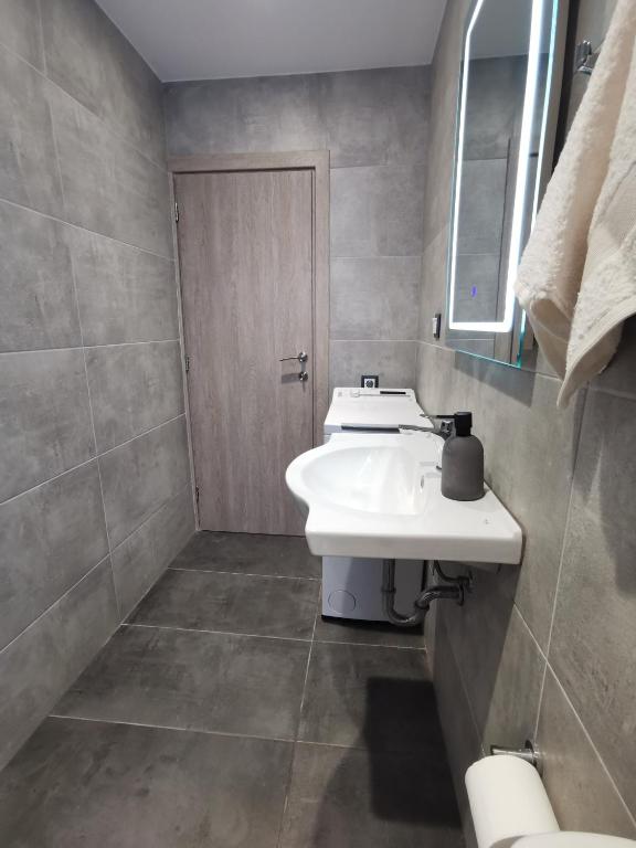 a bathroom with a white sink and a mirror at Mantalena's house in Antiparos