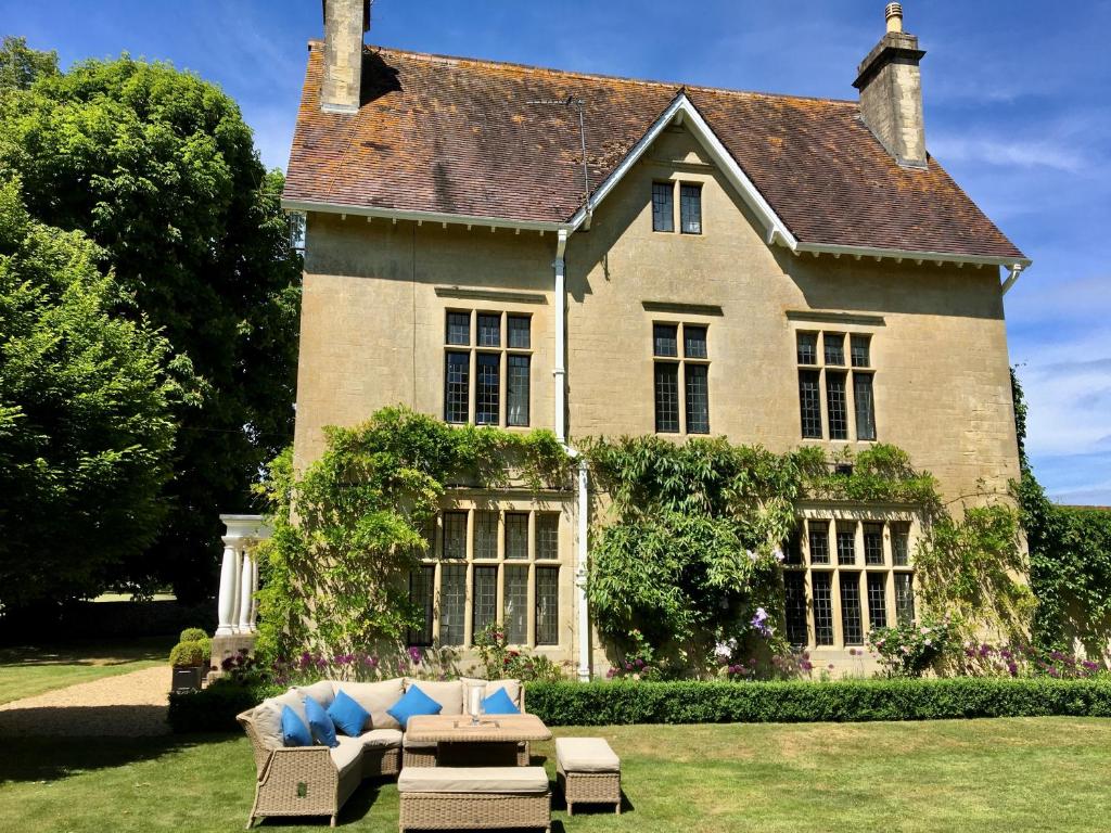 a large house with a couch in front of it at Parsonage House, Badminton in Great Badminton